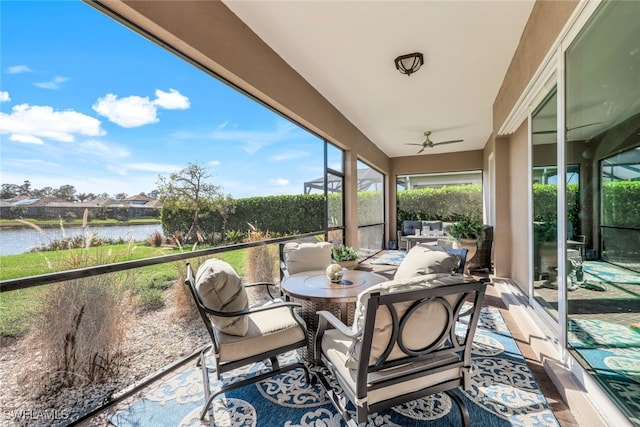 sunroom / solarium featuring a water view and ceiling fan