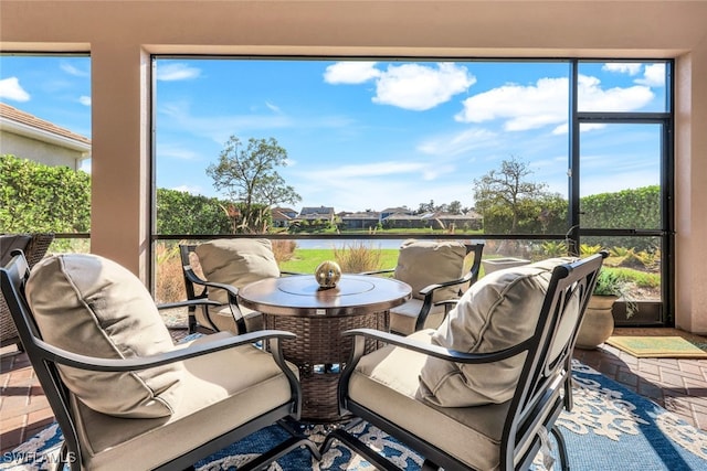 sunroom / solarium with a water view and a wealth of natural light