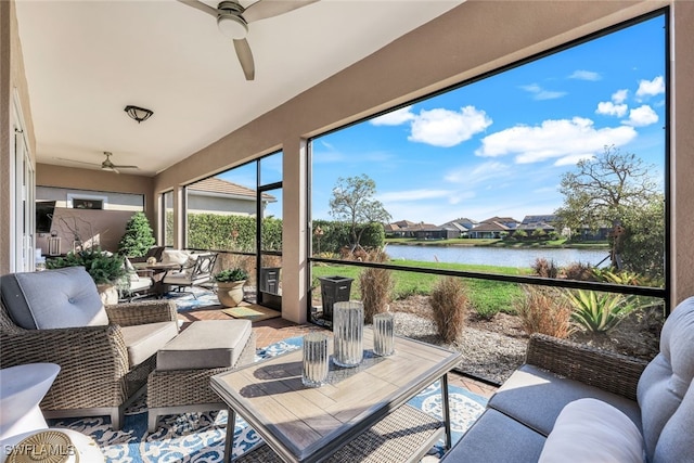 sunroom / solarium featuring ceiling fan and a water view