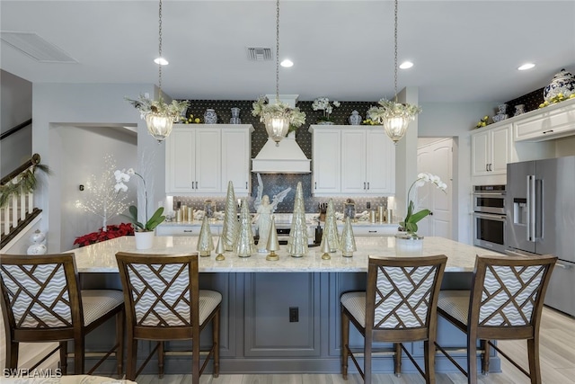 kitchen featuring decorative light fixtures, stainless steel appliances, and a spacious island