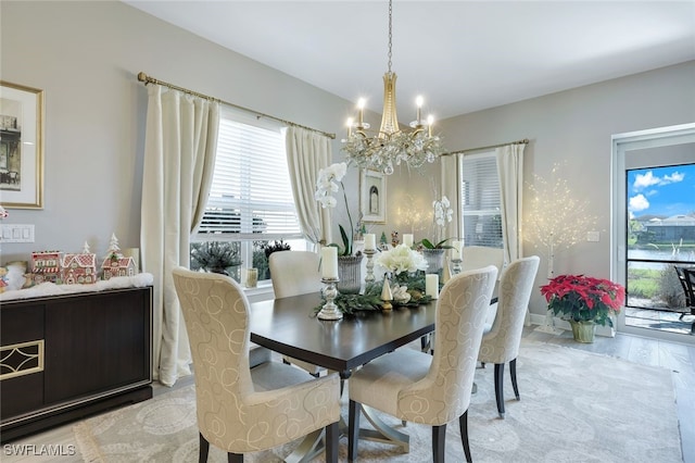 dining area with light hardwood / wood-style floors and an inviting chandelier