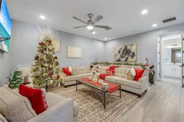 living room featuring ceiling fan, a healthy amount of sunlight, and light wood-type flooring