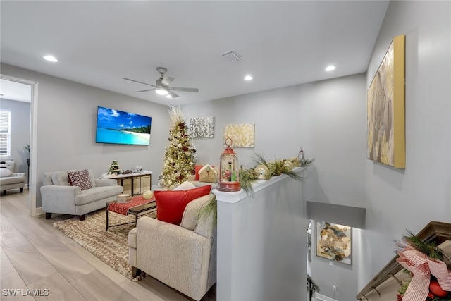 living room with light hardwood / wood-style floors and ceiling fan