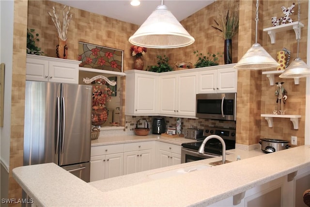 kitchen featuring appliances with stainless steel finishes, backsplash, white cabinetry, and pendant lighting