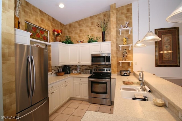 kitchen featuring appliances with stainless steel finishes, sink, white cabinets, hanging light fixtures, and light tile patterned flooring