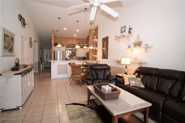 living room featuring ceiling fan, light tile patterned flooring, and lofted ceiling