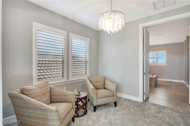 living area with light tile patterned floors and an inviting chandelier