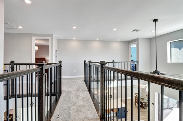 hallway with recessed lighting, visible vents, light carpet, and baseboards