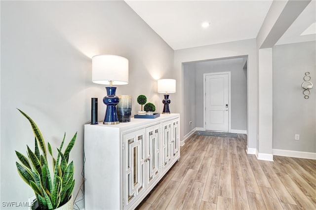 hallway with light wood-type flooring and baseboards