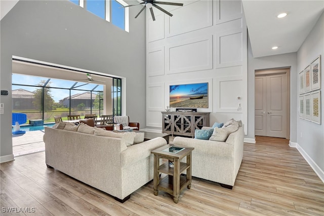 living room with a sunroom, a healthy amount of sunlight, and light wood finished floors