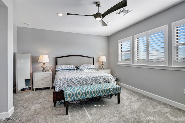 bedroom with a ceiling fan, visible vents, light carpet, and baseboards