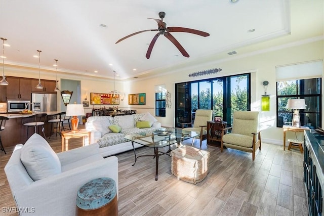 living room featuring ceiling fan and crown molding