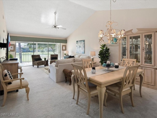 dining space with high vaulted ceiling, ceiling fan with notable chandelier, light colored carpet, and a textured ceiling