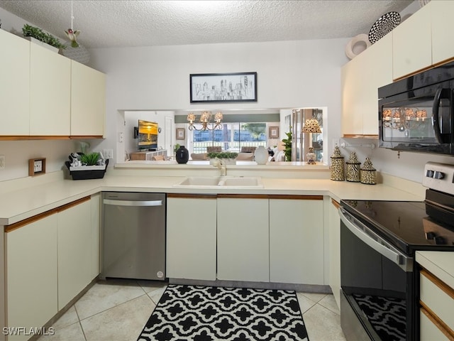 kitchen featuring appliances with stainless steel finishes, sink, light tile patterned floors, kitchen peninsula, and a textured ceiling