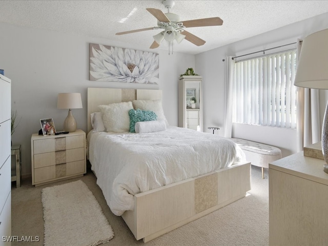 carpeted bedroom with ceiling fan and a textured ceiling