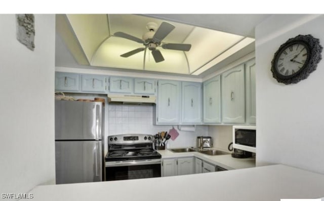 kitchen featuring kitchen peninsula, appliances with stainless steel finishes, tasteful backsplash, vaulted ceiling, and ceiling fan