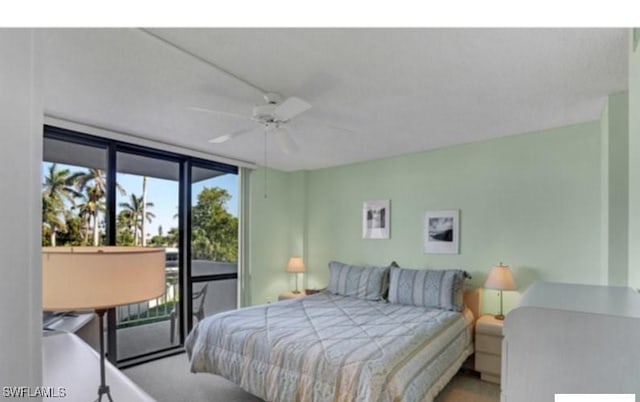 carpeted bedroom featuring access to outside, ceiling fan, and a wall of windows