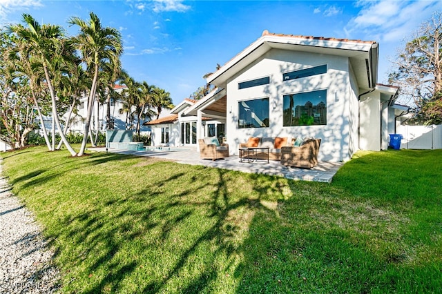 rear view of property featuring a lawn, a patio area, and outdoor lounge area