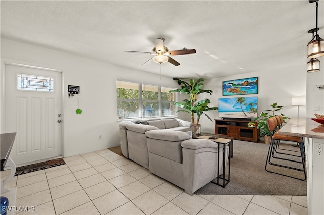 tiled living room with a wealth of natural light, ceiling fan, and a textured ceiling