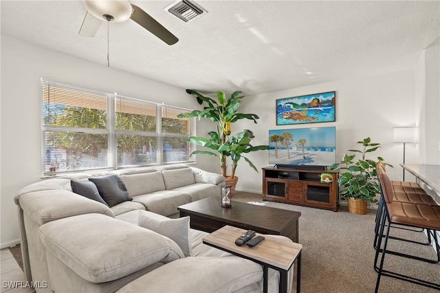 carpeted living room with a textured ceiling and ceiling fan