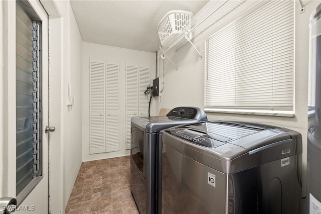 laundry room featuring a textured ceiling and washing machine and clothes dryer