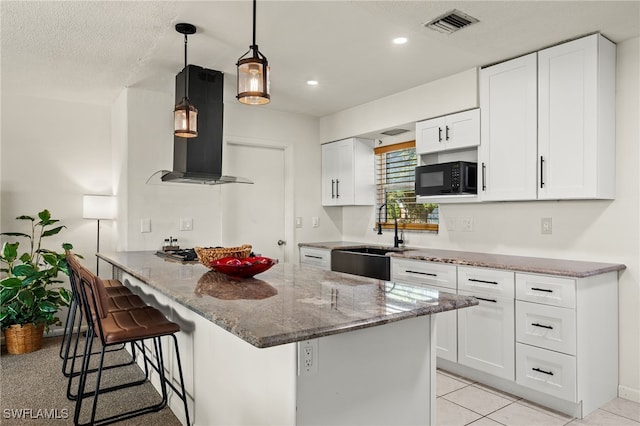 kitchen with stone counters, sink, a kitchen breakfast bar, white cabinets, and exhaust hood