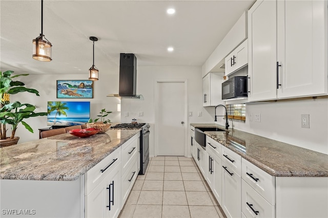 kitchen featuring exhaust hood, white cabinets, sink, stainless steel gas range, and decorative light fixtures