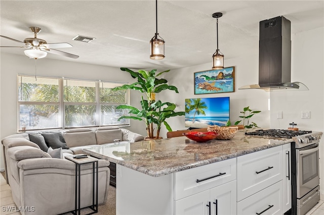 kitchen with ventilation hood, high end stainless steel range, light stone countertops, a kitchen island, and white cabinetry