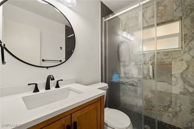 bathroom featuring vanity, toilet, and a shower with door