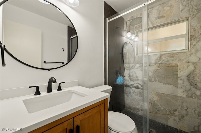 bathroom with vanity, toilet, and a shower with shower door