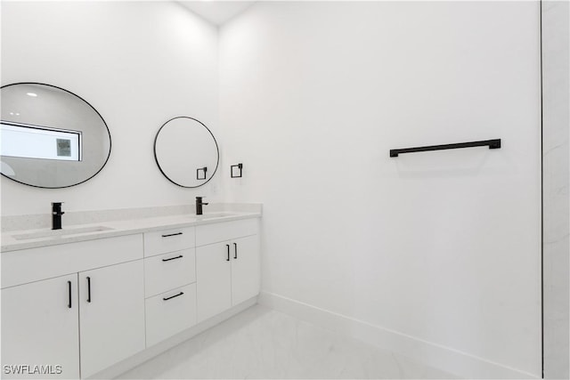 full bathroom with double vanity, a sink, and baseboards