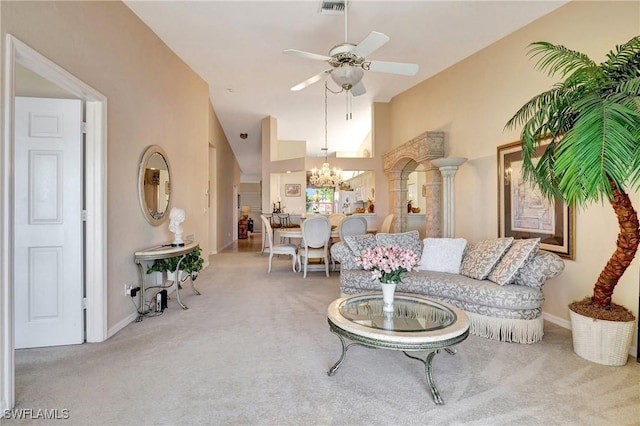 carpeted living room with ceiling fan with notable chandelier and high vaulted ceiling