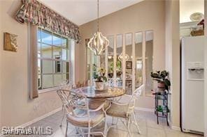 tiled dining space featuring a notable chandelier