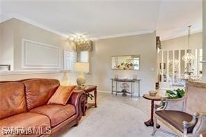 living room featuring crown molding, light colored carpet, and a chandelier