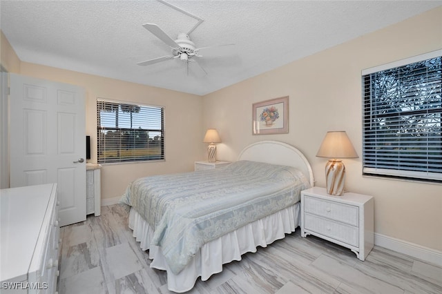 bedroom with a textured ceiling and ceiling fan