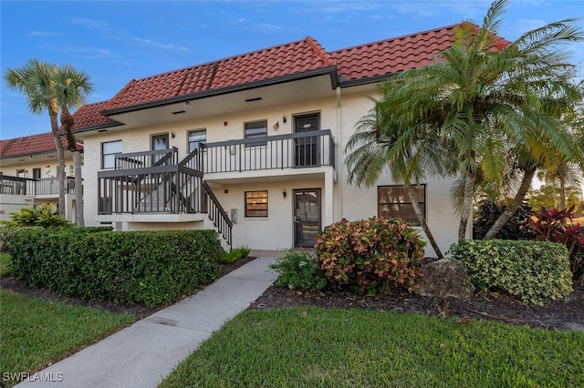 4366 27th Ct SW Unit 1-106, Naples, FL 34116 - view of front of home with a tile roof, stucco siding, and stairs