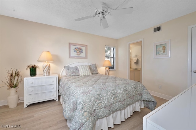 4366 27th Ct SW Unit 1-106, Naples, FL 34116 - bedroom with wood finished floors, a ceiling fan, and connected bathroom