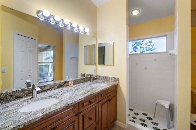 bathroom featuring a tile shower, tile patterned floors, and vanity