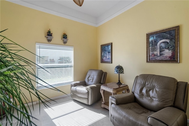 sitting room with carpet, ceiling fan, and ornamental molding