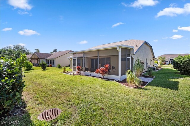 back of property featuring a sunroom and a yard