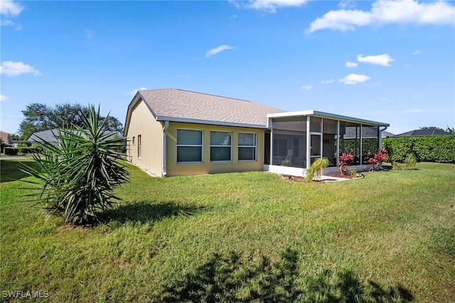 rear view of property featuring a lawn and a sunroom