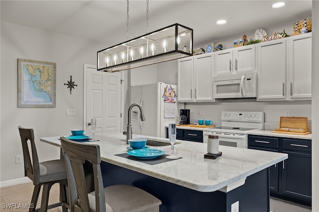 kitchen with sink, decorative light fixtures, white appliances, a center island with sink, and white cabinets