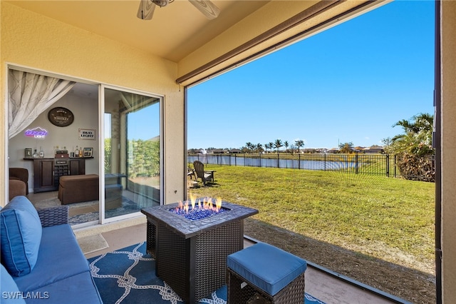 view of patio featuring a water view and ceiling fan