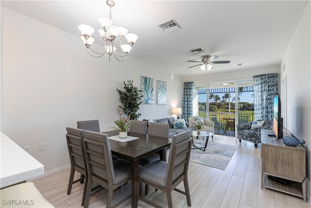 dining area with ceiling fan with notable chandelier and light wood-type flooring