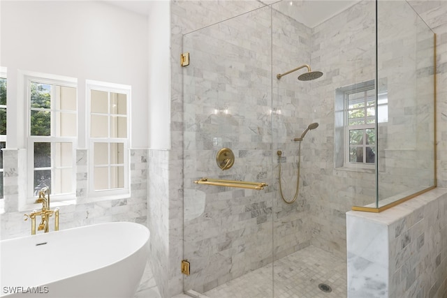 bathroom featuring separate shower and tub, sink, a wealth of natural light, and tile walls