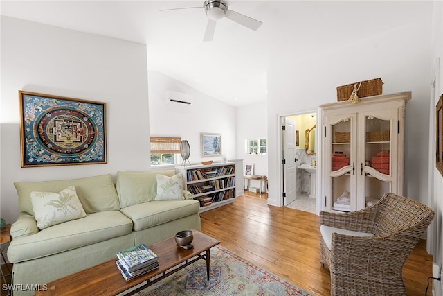 living room with light hardwood / wood-style floors, a wall unit AC, ceiling fan, and lofted ceiling