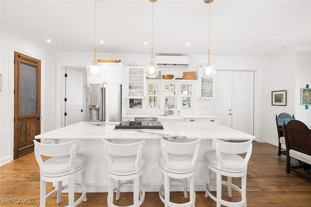 kitchen featuring a kitchen breakfast bar, high end fridge, and hanging light fixtures