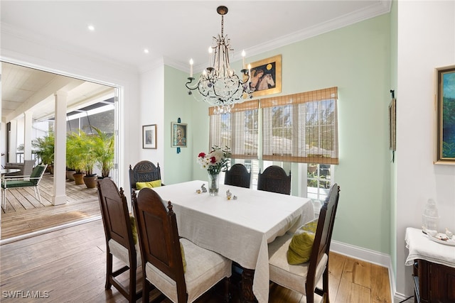 dining room featuring a wealth of natural light, wood-type flooring, a notable chandelier, and ornamental molding