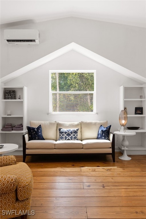 living room with a wall mounted AC, light hardwood / wood-style floors, and lofted ceiling