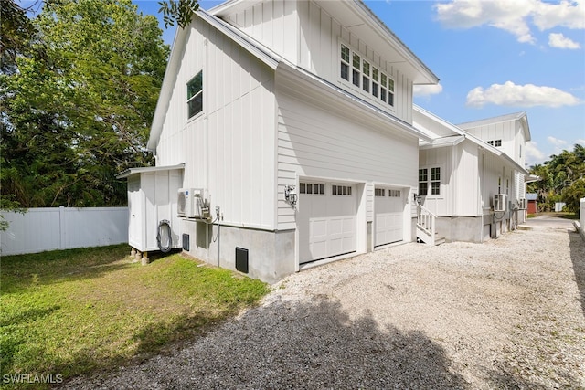 view of property exterior featuring ac unit, a garage, and cooling unit